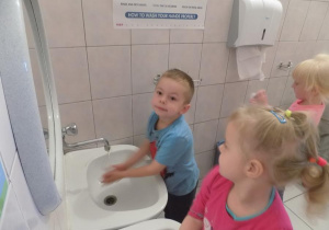 Nikola i Marcel ćwiczą prawidłowe mycie rąk przy umywalce.
